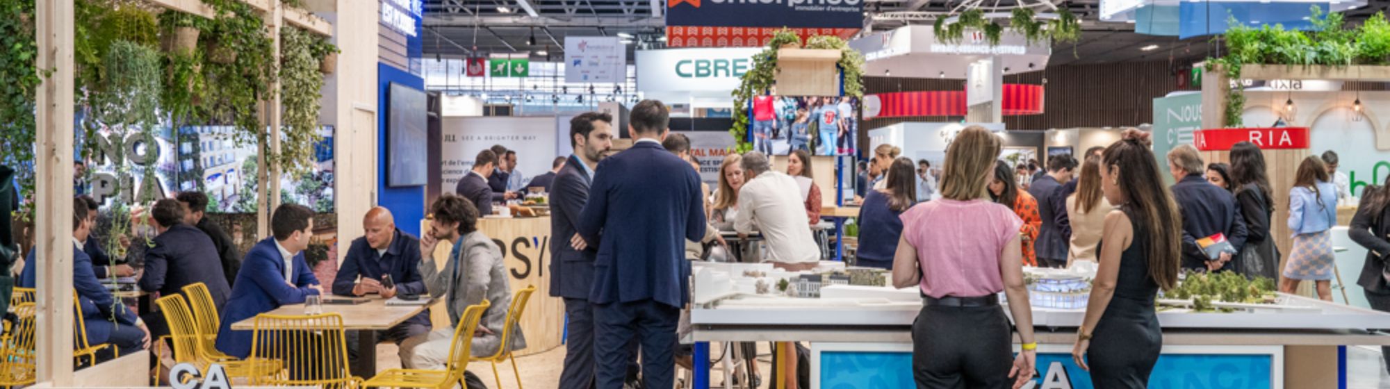 Stand MacArthurGlen au Siec, avec des professionnels en discussion dans l’espace d’exposition.