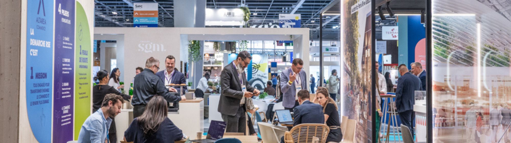 Professionnels en rendez-vous sur un stand au Siec, avec panneaux d'information et espaces de discussion.