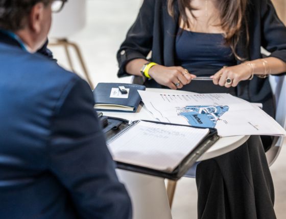 Two professionals discussing documents and a site plan during a meeting at the SIEC commercial real estate event.