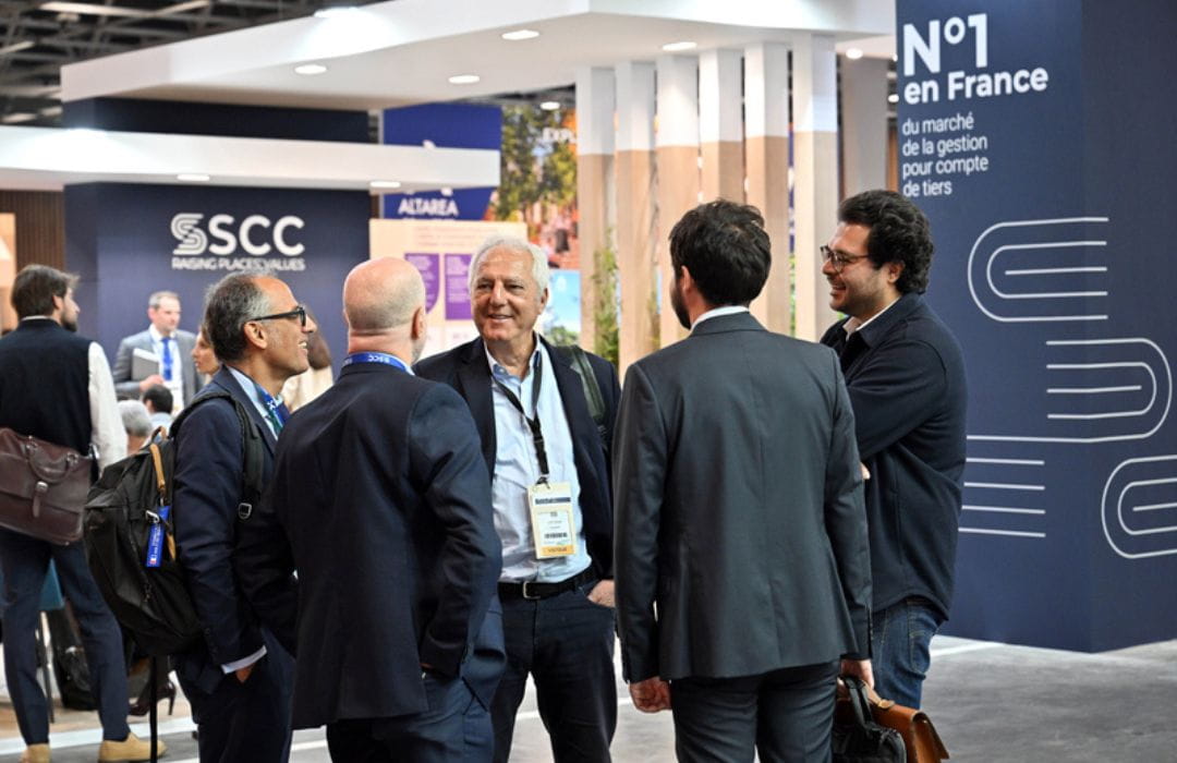 Group of professionals conversing in front of a booth at SIEC, fostering business opportunities.
