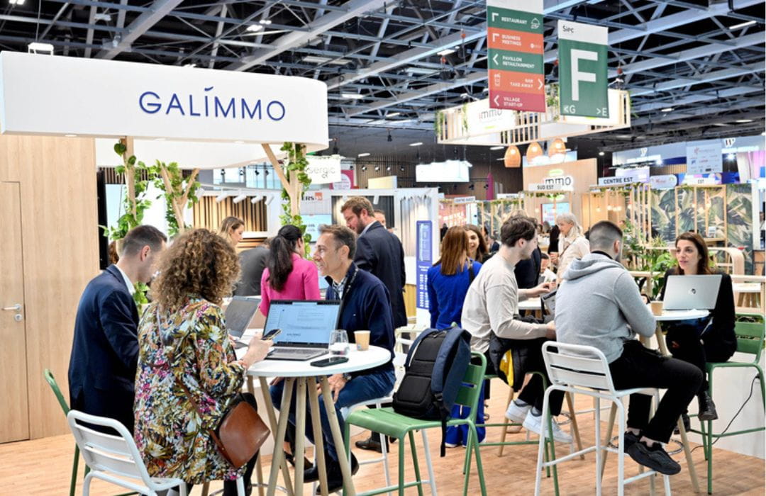 Vue générale d’un salon professionnel animé avec des discussions et des échanges entre participants.